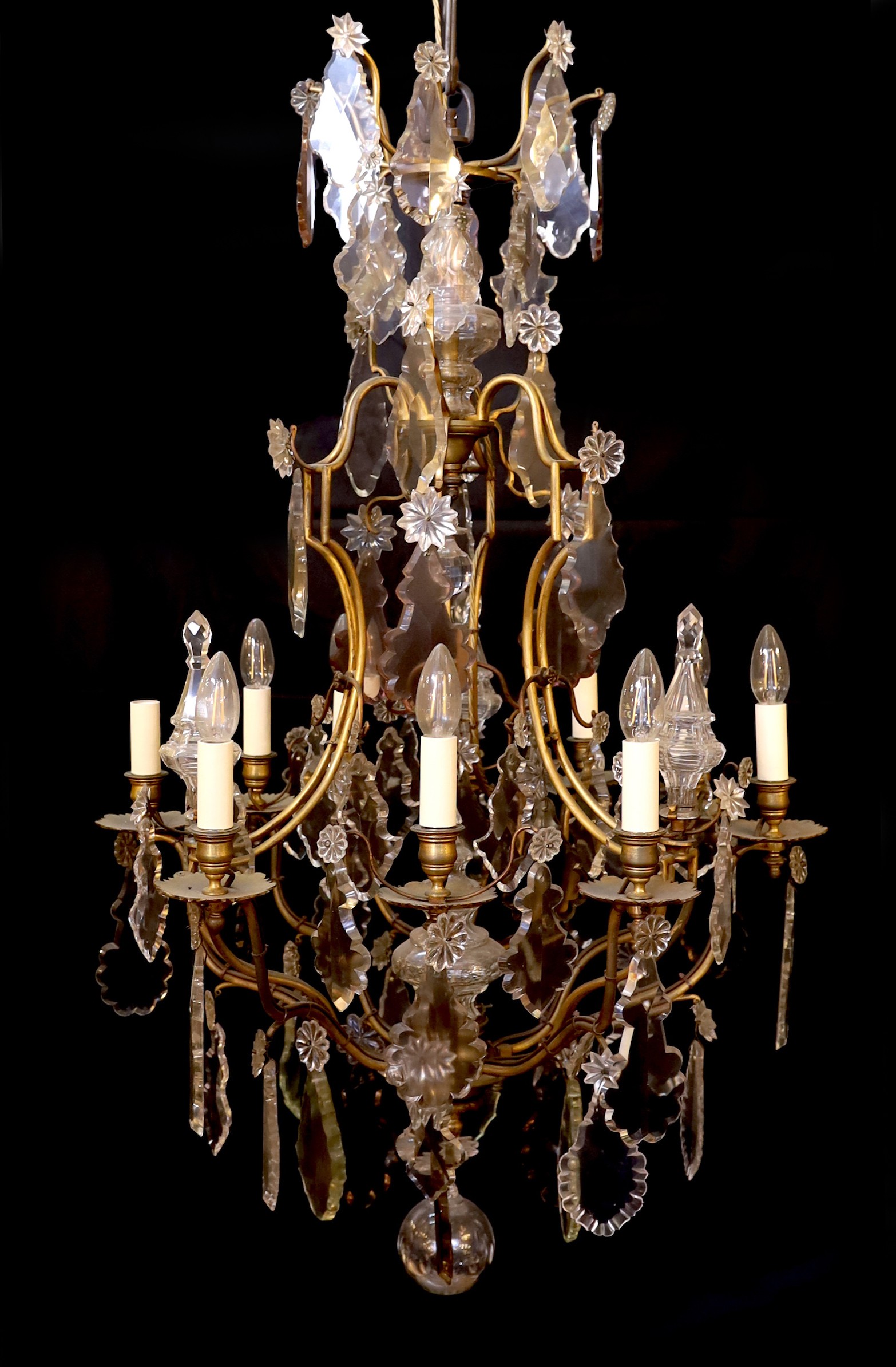 An early 20th century French gilt bronze and cut glass eight light chandelier profusely hung with lozenge and flowerhead drops, drop 110cm. width 65cm
